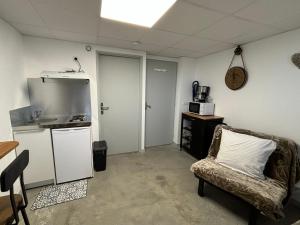 a living room with a couch and a kitchen at Studio, quiet and secure in ZA in Chaingy