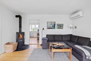 Una sala de estar con un sofá y una chimenea. en LN2028-Hjorring-Mollebakkevej-235-B, en Vester Vidstrup