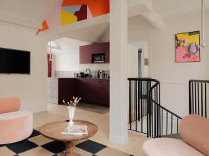 a living room with a couch and a table at Edgar Suites - Lemercier in Paris +31 photos