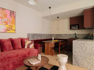 a living room with a red couch and a kitchen at Edgar Suites - Lemercier in Paris