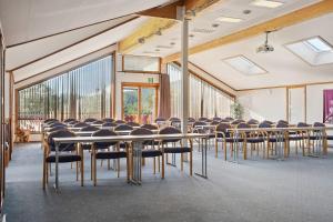 a room with rows of tables and chairs at Heia Gjestegård in Grong