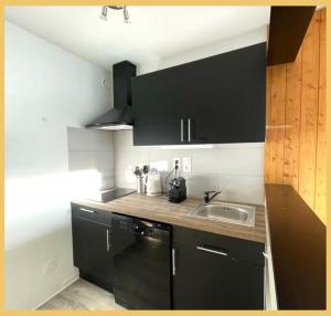 Una cocina con gabinetes negros y un fregadero. en Le Balcon d'Avoriaz I Studio I Morzine, en Morzine 5 fotos más