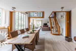a living room with a wooden table and a staircase at De Orangerie in Loenen