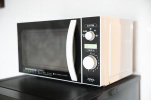 a microwave oven sitting on top of a table at シートピア恩納村Ocean 贅沢快適なデザイナーズ空間と蒼い海 in Onna