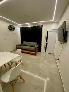 a living room with a couch and a table at Seu Lar de Praia p Família e amigos 400m do Mar em Condomínio in Praia Grande