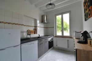 una cocina con electrodomésticos blancos y una ventana en La belle étoile 2 1à6pers 3ch 5lits parking privé, en Brou 5 fotos más