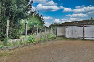 un jardín con una valla y un cobertizo en La belle étoile 2 1à6pers 3ch 5lits parking privé, en Brou