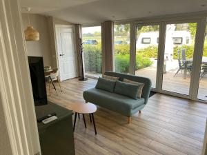 a living room with a couch and a television at Appartement Oisterwijk in Moergestel
