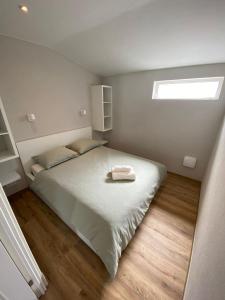 Un dormitorio pequeño con una cama con ventana. en Appartement Oisterwijk, en Moergestel