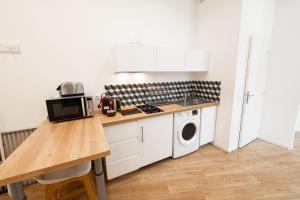 a kitchen with a counter and a washer and dryer at Modern AC Studio in the Heart of Chartrons in Bordeaux