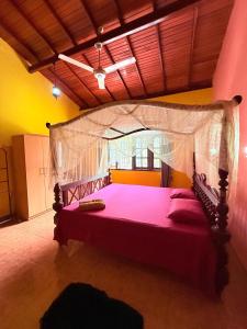 a bedroom with a large bed with a canopy at Utopia Hikka in Hikkaduwa