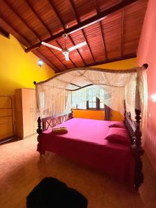 a bedroom with a large bed with a canopy at Utopia Hikka in Hikkaduwa
