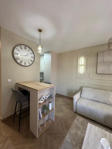 a room with a desk and a bed and a clock at The Wolf Residence in Inđija