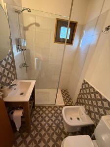 Un baño con inodoro, lavabo y ducha. en RIO-ABAJO Cabañas frente al RIO MELIQUINA, en Villa Meliquina