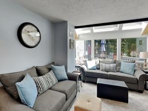 a living room with a couch and a clock on the wall at Arrowhead Village 13 in Thayerville
