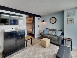 a living room with a couch and a clock on the wall at Arrowhead Village 13 in Thayerville