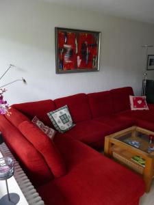 オーバーマイゼルシュタインにあるFerienwohnung Am Goldbach Pool Saunaのリビングルーム(赤いソファ、テーブル付)