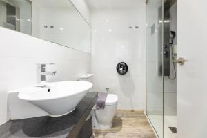a white bathroom with a sink and a toilet at Bristol Sunset Beach - Holiday Apartments in Corralejo