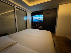 a bedroom with a large white bed and a television at Appartement d'architecte face à la mer in Les Sables-dʼOlonne