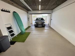 Un coche está aparcado en un garaje con una tabla de surf. en Appartement d'architecte face à la mer, en Les Sables-dʼOlonne