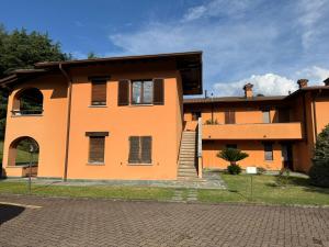 an orange building with a staircase in front of it at Colonia del Lago - Trilocale - Menaggio in Menaggio