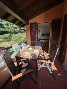 a wooden table and chairs on a patio at Colonia del Lago - Trilocale - Menaggio in Menaggio +9 photos