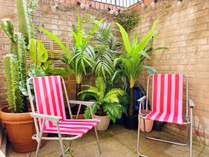 Dos sillas rojas y blancas frente a plantas. en Quirky Apartment Close to town centre and FREE parking, en Cheltenham