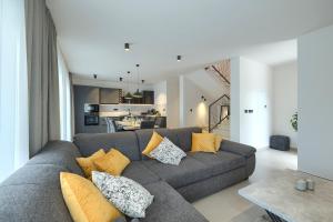 a living room with a gray couch with pillows at Cherry House in Medulin