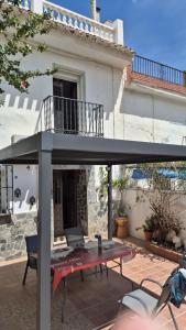 a patio umbrella with a table in front of a house at CASA PACO - Maison Andalousie in Cútar