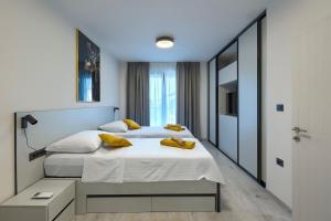 a bedroom with two beds with yellow pillows on it at Cherry House in Medulin
