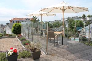 un patio con sombrilla, sillas y mesas en Pension Villa Elisabeth, en Sassnitz 48 fotos más