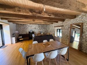 a dining room with a wooden table and white chairs at Nature break in a farmhouse near Vannes in Grand-Champ +15 photos