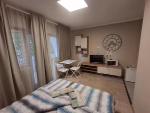 a bedroom with a bed and a desk and a television at Mórocz Vendégház in Balatonboglár
