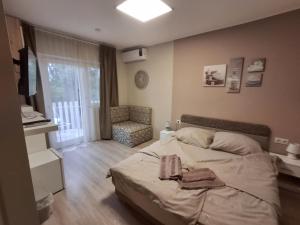 a bedroom with a bed and a chair in it at Mórocz Vendégház in Balatonboglár