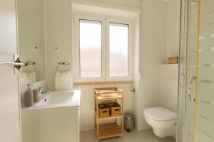a bathroom with a sink and a toilet and a window at BV 01 Apartment in Amadora
