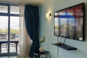 a living room with a flat screen tv on a wall at Seaside Riviera in Cape Town