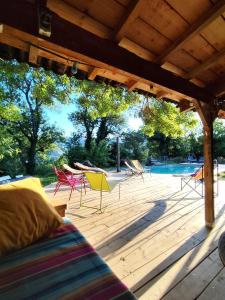 a wooden deck with chairs and a swimming pool at Gîte L'Atelier in Saint Martin sur Lavezon