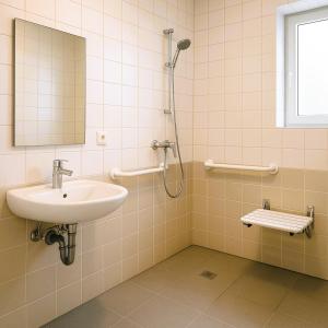 a bathroom with a sink and a shower at LA MAISON DU NORD - Hotel Garni in Cuxhaven