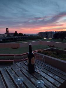 a bottle of wine sitting on a table with two glasses at A Casa di Vale in Nettuno