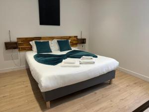 a bedroom with a large bed with two towels on it at Hotel Sennecey - Free Parking - BY PRIMO C0NCIERGERIE in Sennecey-le-Grand