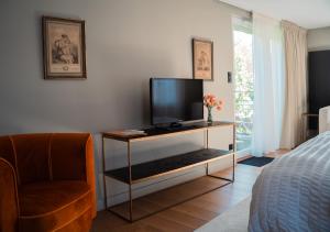 a bedroom with a tv and a chair and a bed at Le Clos Corbier - Champagne Collard-Milesi in Mareuil-sur-Ay
