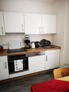 a kitchen with white cabinets and a stove top oven at Das blaue Haus in Zeltingen-Rachtig
