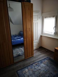 a mirror in a room with a bed and a bedroom at Das blaue Haus in Zeltingen-Rachtig +7 photos