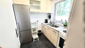 a small kitchen with a refrigerator and a sink at Geräumige Loft in Idyllischer Lage in Delmenhorst
