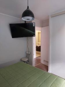 a bedroom with a green bed and a black lamp at Depto cerca playa in La Serena