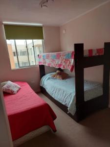 a bedroom with two bunk beds and a window at Depto cerca playa in La Serena +1 photo