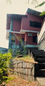 una casa roja con escaleras delante en Recanto do sol, en Mangaratiba