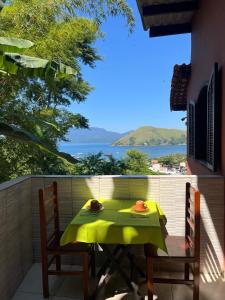 Una mesa y sillas en un balcón con vista al mar. en Recanto do sol, en Mangaratiba