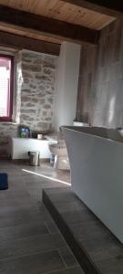 a bathroom with a white counter and a stone wall at Chambre double chez Emilienne  +5 photos