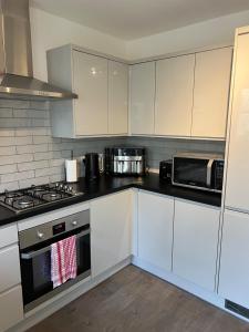 a kitchen with white cabinets and a stove top oven at Ground Floor Flat BishopAuckland in Bishop Auckland +5 photos